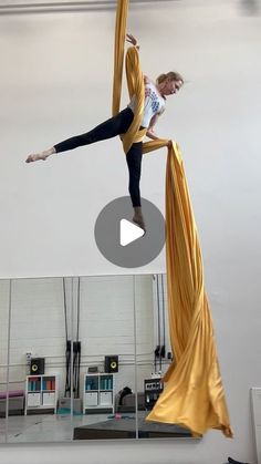 a woman is doing tricks on a pole in the middle of a room with mirrors