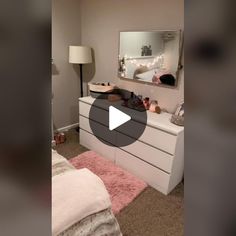 a bedroom with a dresser, mirror and pink rugs on the carpeted floor