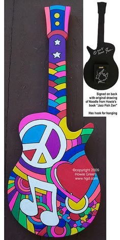 an image of a colorful guitar with music notes on the neck and peace sign painted on it