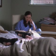 a woman laying in bed talking on the phone