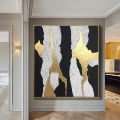 an abstract painting hangs on the wall next to a wooden floor in a modern living room