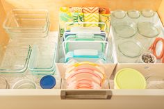 an organized drawer filled with plastic containers and plates