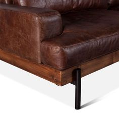 a brown leather couch sitting on top of a wooden table