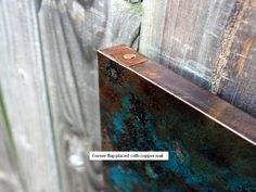 an old rusted metal door handle on a wooden fence