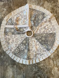 an old paper plate with a clock on it sitting on a wooden table next to a pair of scissors