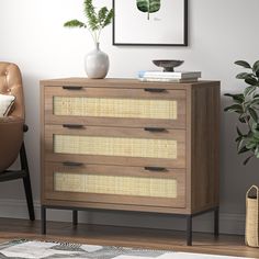 a wooden dresser sitting next to a chair and potted plant on top of it