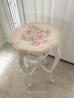 a white table with flowers painted on it