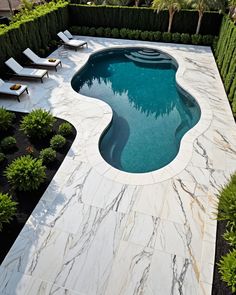 an outdoor swimming pool surrounded by greenery