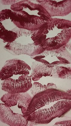 lipstick kisses drawn on white paper with red and pink inks in the middle, all lined up