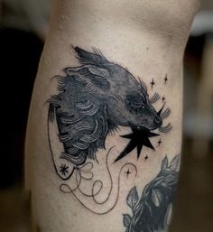 a tattoo on the leg of a person with a boar head and stars around it