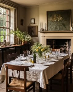 a dining room table is set with white linens and yellow flowers in vases