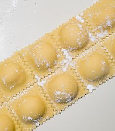 doughnuts with powdered sugar are arranged on a white surface