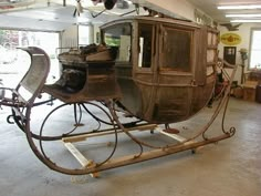 an old fashioned horse drawn carriage in a garage