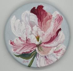 a pink and white flower painted on a button