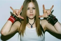 a woman with her hands in the air and two fingers up above her head, making peace signs