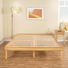 a wooden bed frame in a room with hard wood floors