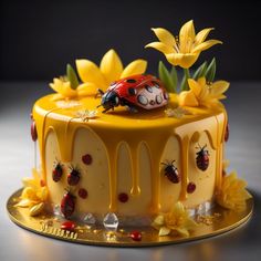 a cake with yellow icing and ladybugs on top, surrounded by sunflowers