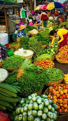 an outdoor market with lots of vegetables and fruits