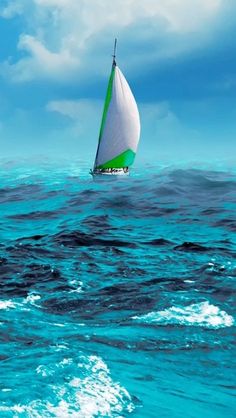 a sailboat floating in the ocean on a cloudy day with blue sky and white clouds