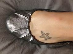 a person's foot with a small tattoo on the side of their left leg