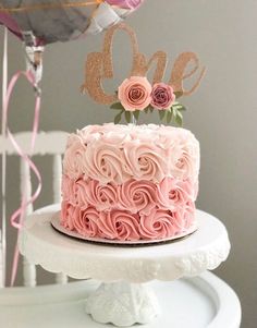 a cake with pink frosting and roses on top