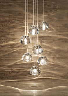 a chandelier hanging from a wooden ceiling with glass balls on the bottom and sides