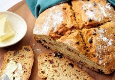 a loaf of bread sitting on top of a wooden cutting board next to butter and a knife