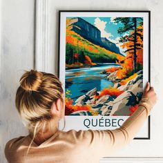 a woman is looking at a poster hanging on the wall above her head, which reads quebec