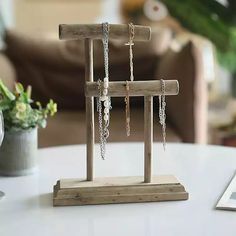 a small wooden stand with chains hanging from it's sides on a white table