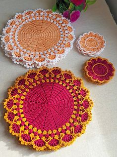 crocheted doily and coasters on a table with flowers in the background