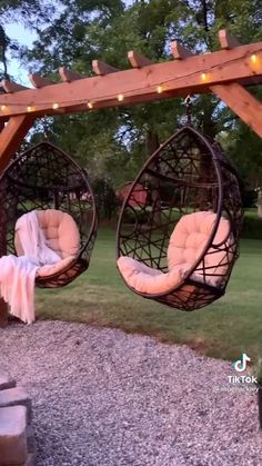 two hanging chairs in the middle of a yard