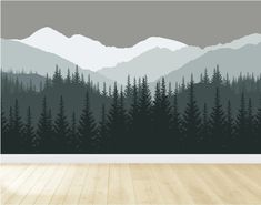 an empty room with wood flooring and wallpaper on the walls is decorated with a forest scene