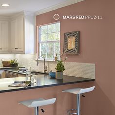 a kitchen with two stools next to the counter