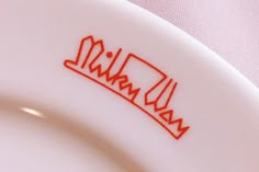 a white plate with red lettering on it and the word malwa written in red