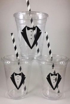 four plastic cups with black and white striped straws in tuxedo designs on them