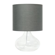 Illuminate your living space with this simple yet stylish glass table lamp. The clear glass raindrop shaped base and gray fabric drum shade is the perfect blend of charm to give your home a contemporary and modern upgrade. Perfect for living rooms, bedrooms, kids and teens, college dorms, apartments, nurseries, or offices. Size: 9" x 9" x 13.75". Small Glass Bedside Lamps, Grey Side Table Lamps, Grey Desk Lamp, Light Grey Lamp Shade, Grey Glass Table Lamp, Grey Glass, Home Decor Lights, Glass Table Lamp, Decor Lighting