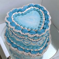 a heart shaped blue cake sitting on top of a table