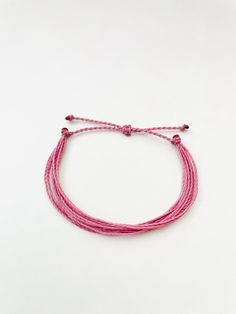 This fun and simple pink string bracelet is waterproof and adjustable, making it great for anyone who is often doing outdoor activities. It would make a nice gift. Stack it with other bracelets, or wear it by itself! It is perfect for everyday wear! ∙ ∙ ∙ ∙ ∙ ∙ ∙ ∙ ∙ ∙ ∙ ∙ ✦ PLEASE NOTE ✦ When you first receive this bracelet, it may feel slightly waxy, which may make it more difficult to adjust. The waxy texture does not last. After a day or two of wearing, the waxy texture will fade, and it wil Trendy Pink Bracelet With Adjustable Length, Trendy Pink Adjustable Bracelet, Pink Adjustable Band Bracelet For Gift, Adjustable Pink Friendship Bracelets, Pink Adjustable Friendship Bracelets As Gift, Casual Pink Braided Bracelets As Gift, Minimalist Pink Friendship Bracelets, Pink Adjustable Friendship Bracelets, Pink Resizable Friendship Bracelets For Beach