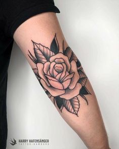 a black and white rose tattoo on the arm