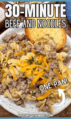 a white plate topped with pasta and sausage next to bread on a tablecloth covered table