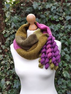 a white mannequin wearing a purple and green scarf