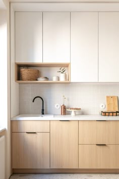 a kitchen with wooden cabinets and white counter tops, along with a sink that has a black faucet on it