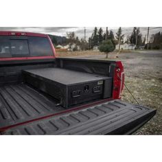 the back end of a red truck with an open trunk compartment on it's bed