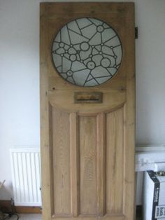 a wooden door with a stained glass window on the top and bottom panel, in front of a radiator