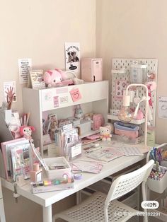 a white desk topped with lots of items next to a chair and table covered in toys