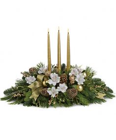 a centerpiece with pine cones, white flowers and gold candles