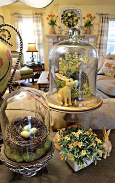 a clochet filled with fake plants and eggs under a glass dome on top of a table