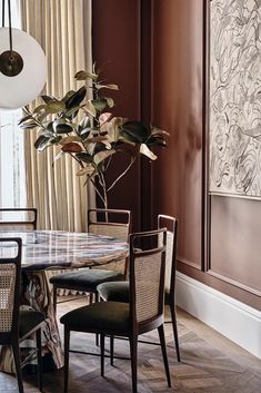 a dining room table with chairs and a potted plant