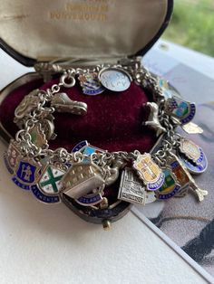 This is one big charm bracelet with 45 charms, many European crested enamel pieces and 17 Figural charms including two spinners, one says GOOD Luck, the other I LOVE you. The charms span from the 1950s to 1970s. My own particular favourite is the articulated fish with Ruby eyes.  Weight 73.3 Grams, Cable chain measuring 7 1/2". The longest charm is the fish. Charms are stamped Sterling, silver, argent, 800:and some are hallmarked. The charm fastens with a Spring ring, I have a small new Padlock Vintage Charm Bracelet 1stdibs, Cheap Vintage Charm Bracelet, Cheap Vintage Bracelets With Charms, Affordable Silver Bracelet With Vintage Charm, Cheap Silver Charm Bracelet With Vintage Charm, Luxury Heirloom Style Bracelets With Vintage Charm, Luxury Metal Charm Bracelet With Vintage Charm, Vintage Charm Bracelet Silver, Antique Charm Bracelet As Gift