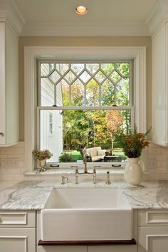 a white kitchen sink sitting under a window